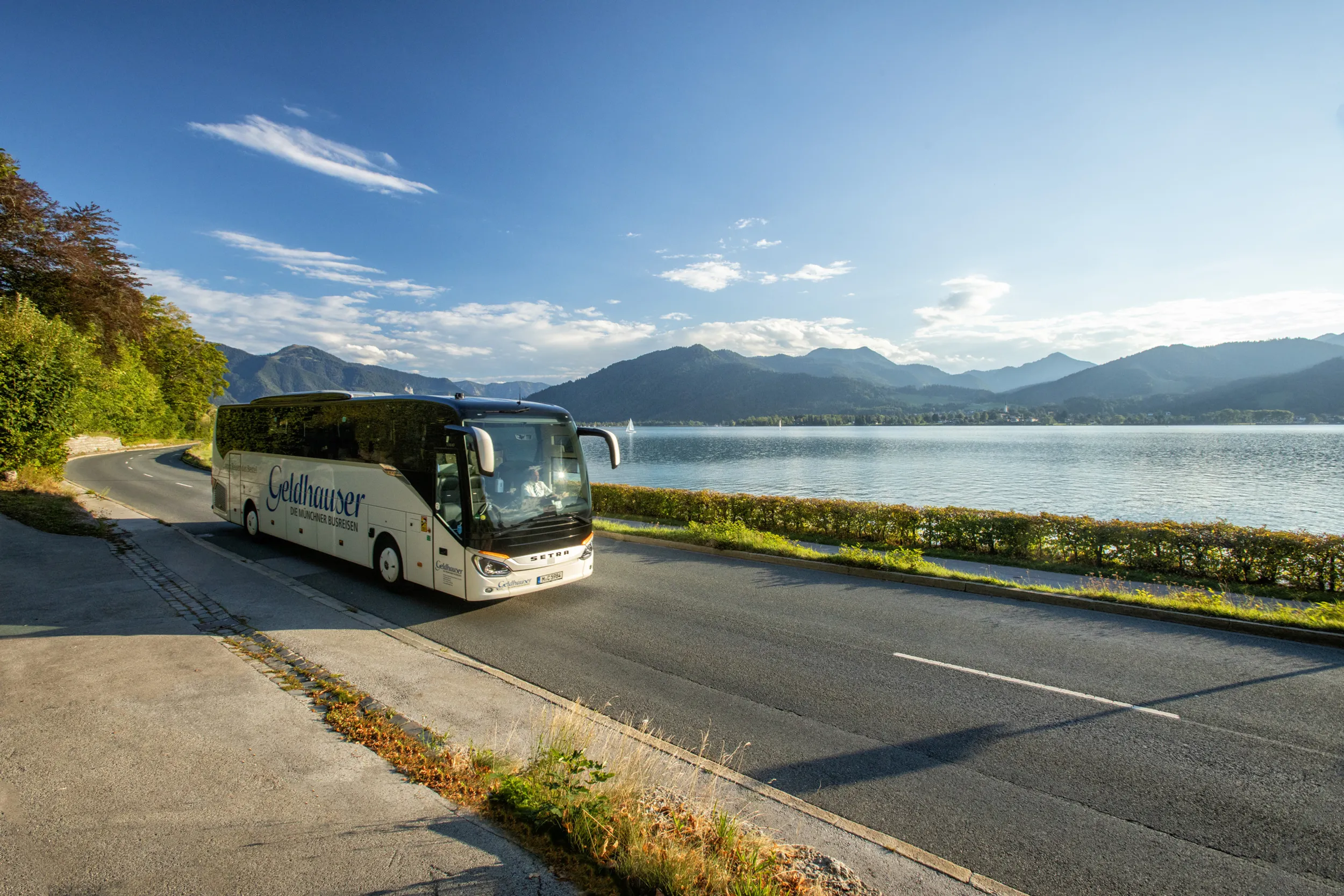 Geldhauser Fernreisebus fährt an einem See vorbei